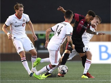 Ottawa Fury FC's Kevin Oliveira (88) tries to keep the ball from Toronto FC's Jay Chapman (14) and Liam Fraser (27) during first half Canadian Championship soccer action in Ottawa on Wednesday, July 18, 2018.