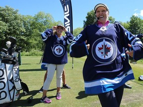 Brook Henderson (right), LPGA golfer from Smiths Falls, Ont., and sister Brittany, her caddie, model Winnipeg Jets jerseys gifted to them following a clinic at St. Charles Country Club in Winnipeg on Tues., July 17, 2018 .
