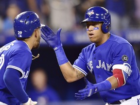 Blue Jays third baseman Yangervis Solarte, right, celebrates his two-run home run against the Orioles with teammate Devon Travis during eighth inning MLB action in Toronto on Sunday, July 22, 2018.