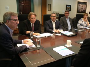 Ottawa Mayor Jim Watson, left, talks with Eugene Melnyk, second from the left, and John Ruddy, right, during a meeting about the LeBreton Flats project on Friday, Aug. 10, 2018.