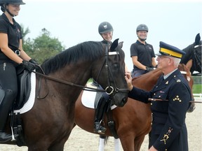 Sgt. Major Martin Kohnen, Riding Master for the RCMP Musical Ride, chats with horse trainers at the RCMP stables, where they took out some of the horses   for exercise earlier this week.   Julie Oliver/Postmedia