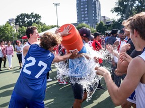 Chelsea Phoenix Field Hockey Club boys' U18 general manager Bill Syrros gets doused by Robert Campe (No. 27) and Philippe Bezzenberger. (Kevin Underhill/Field Hockey Canada)
