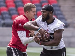 Redblacks tailback William Powell, right, takes a handoff from QB Trevor Harris during practice earlier this week. Errol McGihon/Postmedia