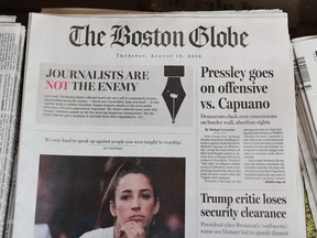 The front page of the Aug. 16, 2018 edition of the Boston Globe reads "Journalists are not the enemy" as it sits for sale at Out of Town News in Cambridge, Mass.