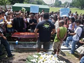 Relatives and friends of Karine Lorraine, one of the students slaughtered on Thursday at a school, express their sorrow next to her coffin at Jardim da Saudade cementery in Rio de Janeiro on April 08, 2011. (ANTONIO SCORZA/AFP/Getty Images)