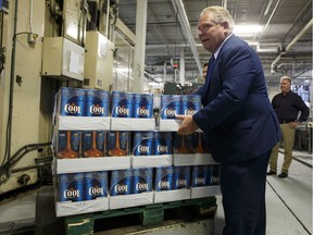 Ontario Premier Doug Ford holds a case of beer during a photo opportunity at a brewery in Etobicoke, Ont. on Monday, Aug. 27, 2018. Buck a beer went into effect in Ontario on Monday, but only a handful of brewers have embraced the new, lower minimum price.