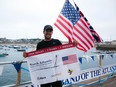 In this Saturday, Aug. 4, 2018 photo provided by Bryce Carlson Adventures, Bryce Carlson poses for a photo after completing his solo unsupported row across the Atlantic, at St Mary's Harbour, Isle of Scilly, England.