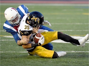 Alouettes quarterback Johnny Manziel is forced to make a tackle of Tiger-Cats defensive back Mike Daly (35) after throwing one of his four first-half interceptions on Friday night.