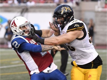 Alouettes quarterback Johnny Manziel (2) receives a hit from Tiger-Cats defensive end Jason Neill (96) during the first quarter.