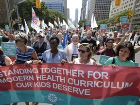 Ontario elementary teachers supporters make their way up University Ave. in Toronto protesting the Ontario government's rollback of the province's sexual education curriculum on Tuesday.