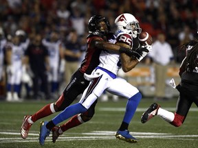 Redblacks cornerback Jonathan Rose (9) reaches for the ball around Alouettes receiver B.J. Cunningham in the first half.