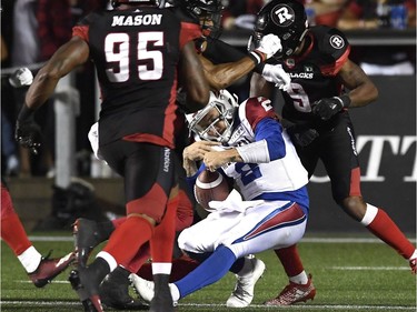 Alouettes quarterback Johnny Manziel (2) is drilled by Redblacks defenders as he approaches the goal-line in the second half. Manziel fumbled, but the ball was recovered by teammate Kristian Matte for a touchdown.