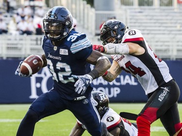 Toronto Argonauts running back James Wilder Jr. (32) is challenged by Ottawa Redblacks defensive back Anthony Cioffi (24) during second quarter CFL action in Toronto on Thursday, August, 2, 2018.