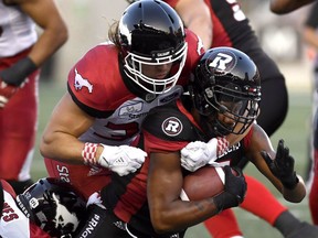 Ottawa Redblacks Loucheiz Purifoy (5) is tackled by Calgary Stampeders Ante Milanovic-Litre (34) during first half CFL action in Ottawa on Thursday, July 12, 2018. The Redblacks have released defensive back Purifoy, the team announced Monday.