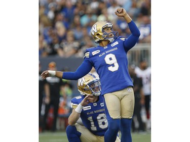 Blue Bombers holder Bryan Bennett (18) and kicker Justin Medlock (9) watch as the ball sails through the goalposts for a successful convert on Darvin Adams' first-half touchdown reception.