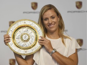 Angelique Kerber shows off the Wimbledon singles trophy during a news conference in Germany in July, days after she defeated Serena Williams to claim that title. Marijan Murat/dpa via AP