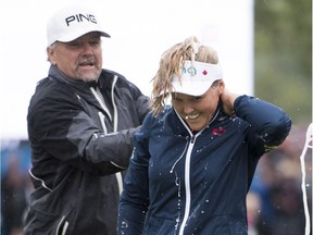 Dave Henderson, left, sprays his daughter Brooke Henderson with champagne after she clinched victory in the CP Women's Open at Regina on Sunday.