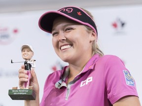 Brooke Henderson of Smiths Falls holds up a bobblehead made in her likeness while speaking to media during a pre-tournament news conference for the CP Women's Open on Tuesday. The figurines are a promotion by Golf Town, one of Henderson's corporate sponsors, in support of young female golfers.