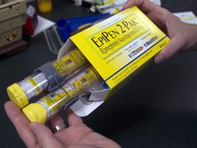 A pharmacist holds a package of EpiPen epinephrine auto-injectors, a Mylan product, in Sacramento, Calif., July 8, 2016. (Rich Pedroncelli/The Canadian Press/AP)