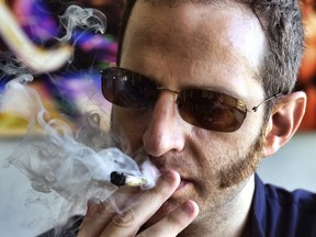 In this Saturday, Aug. 25, 2018 photo, Judd Weiss takes a puff of a pre-rolled marijuana cigarette at his house in the Bel Air section of Los Angeles.