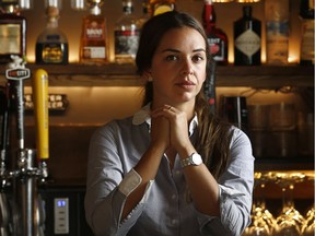 Chef and owner Daniela Manrique poses at the restocked bar of The Soca Kitchen. The thieves 'left us with three bottles,' she said.