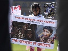 A girl holds a sign protesting the killing of the Rohingya people in Myanmar during a rally for Rohingya Genocide Remembrance Day on Parliament Hill on Saturday.