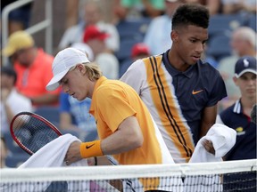 Canada's Denis Shapovalov, left, and Felix Auger-Aliassime change sides during their first-round match at the U.S. Open on Monday. Auger-Aliassime retired with Shapovalov leading in the third set.