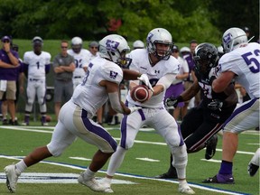 Mustangs quarterback Chris Merchant (12) hands the football off to running back Alex Taylor (5) during Sunday's game against the Ravens. Western won 26-23 in overtime. Valerie Wutti/Carleton Ravens