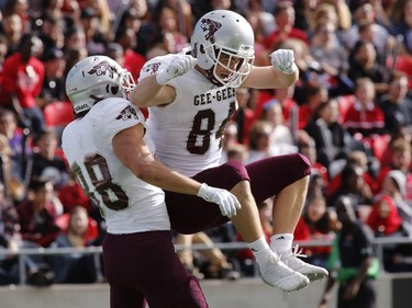 The University of Ottawa Gee-Gees' Dylan St. Pierre (88) celebrates catching a touchdown pass with Harrison Tallyhoe.