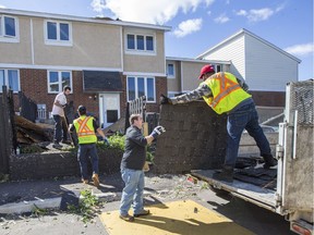 A crew helps with the cleanup from storm damage at the Quarry Co-op on McCarthy Road in Ottawa.