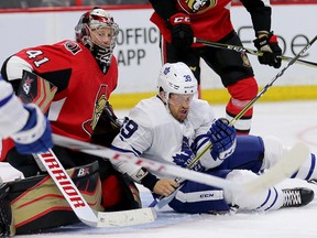 Leafs' Rich Clune is upended in front of Senators goalie Craig Anderson during Wednesday's game. (WAYNE CUDDINGTON/Postmedia Network)