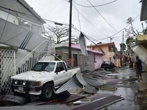 Residents of San Juan, Puerto Rico, deal with damages to their homes on Sept. 20, 2017, as Hurricane Maria batters the island.