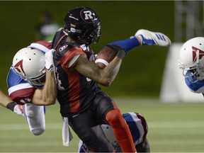 Ottawa Redblacks wide receiver R.J. Harris (84) is stopped by Montreal Alouettes linebacker Chip Cox (11) during first half CFL action in Ottawa on Friday, Aug. 31, 2018.