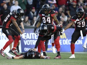 Ottawa Redblacks quarterback Trevor Harris (7) taps his hand on the chest of wide receiver Greg Ellingson (82) as he and teammates Diontae Spencer (85), R.J. Harris (84), celebrate Ellingson's touchdown against the Edmonton Eskimos during second half CFL football action in Ottawa on Saturday, Sept. 22, 2018.