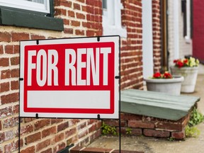 Red For Rent sign closeup against brick building