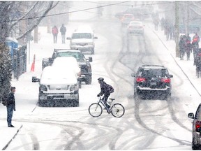 A lone cyclist as snow fell on Ottawa, April 06, 2016.