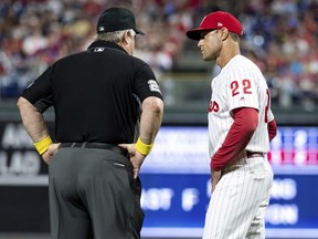 Umpire Joe West, left, talks with Phillies manager Gabe Kapler, right, about the situation with relief pitcher Austin Davis during the eighth inning of a game against the Cubs, in Philadelphia, Saturday, Sept. 1, 2018.