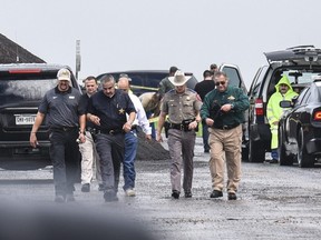 Law enforcement officers gather near the scene where the body of a woman was found near Interstate 35 north of Laredo, Texas on Saturday, Sept. 15, 2018.