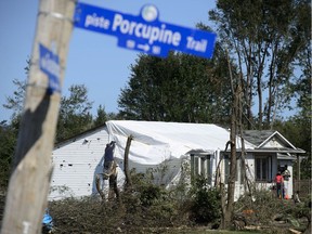 People tarp their damaged home in Dunrobin, Ont. west of Ottawa on Monday, Sept. 24, 2018, following a tornado that hit the area on Friday, Sept, 21.