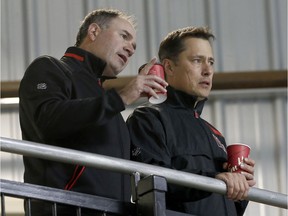 Ottawa Senators general manager Pierre Dorion, left, and coach Guy Boucher look on during training camp at the Canadian Tire Centre. 'It's up for grabs, that's for sure,' Boucher said of the open positions on the Sens' roster. 'Everybody who is here has deserved to be here up to now, and now it's tough decisions.'