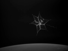 In this September 2018 image made from video provided by the University of Surrey, a net is launched from the International Space Station to catch a test object.