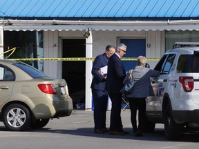 Detectives with Kingston Police stand in front of the Kozy Inn where a 38-year-old man was killed in an overnight shooting. A male suspect, 19, is in custody in Kingston, Ont. on Wednesday, Sept. 5, 2018. Elliot Ferguson/The Whig-Standard/Postmedia Network