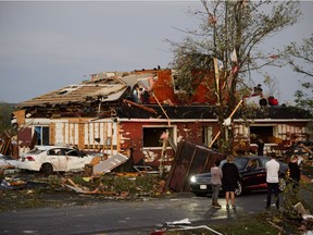 People collect personal effects from damaged homes following a tornado in Dunrobin on Friday.