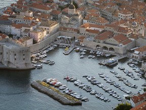 This Sept. 4, 2018 photo shows the harbor in the old town of Dubrovnik from a hill above the city. Crowds of tourist are clogging the entrances into the ancient walled city, a UNESCO World Heritage Site, as huge cruise ships unload thousands more daily.