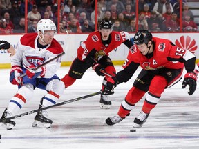 Max Domi #13 of the Montreal Canadiens chips the puck past Zack Smith #15 of the Ottawa Senators in the third period at Canadian Tire Centre on October 20, 2018 in Ottawa.