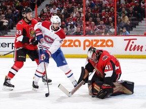 Craig Anderson #41 of the Ottawa Senators makes a save against Phillip Danault #24 of the Montreal Canadiens as Christian Jaros #83 of the Ottawa Senators looks on in the first period at Canadian Tire Centre on October 20, 2018 .