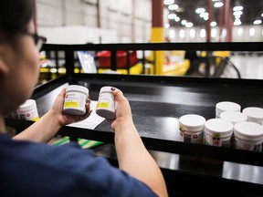 A worker examines cannabis products at the Ontario Cannabis Store distribution centre in an undated handout photo.