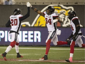 Ottawa Redblacks Kyries Hebert (34) celebrates with teammate Jean-Philippe Bolduc (20) after making an interception during second half CFL Football game action against the Hamilton Tiger-Cats in Hamilton, Ont. on Saturday, October 27, 2018.