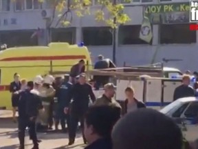 In this image made from video, showing the scene as emergency services load an injured person onto a truck, in Kerch, Crimea, Wednesday Oct. 17, 2018. An explosive device has killed several people and injured at least 50 others at a vocational college in Crimea Wednesday in what Russian officials have called a possible terrorist attack. (Kerch FM News via AP) KERCH.FM LOGO CANNOT BE OBSCURED