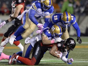 Winnipeg Blue Bombers defensive back Taylor Loffler (16), linebacker Adam Bighill (4) and defensive back Anthony Gaitor (23) bring down Ottawa Redblacks wide receiver Diontae Spencer during first half CFL football action in Ottawa on Friday, Oct. 5, 2018.